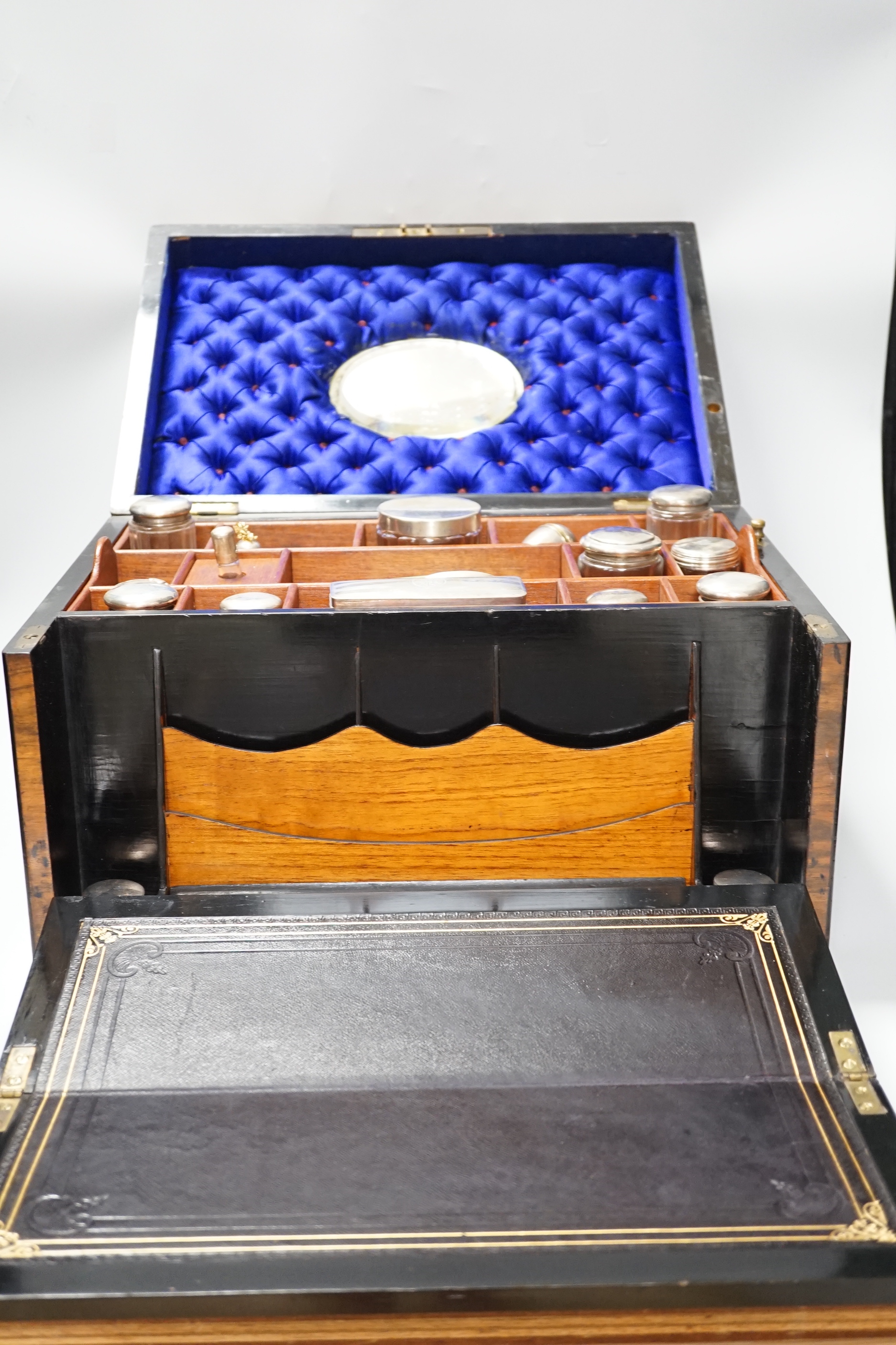 A Victorian combination walnut writing and toilet box, containing various silver lidded glass jars, inset bevelled mirror and other accessories, 40.5cm x 28.5cm x 24.5cm